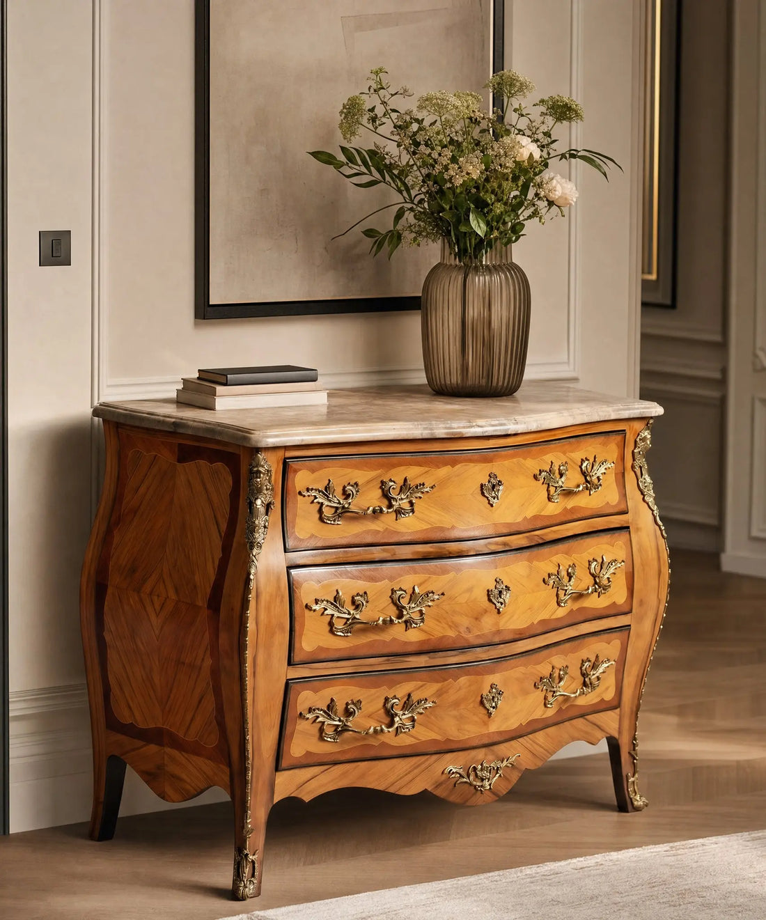 Dormitorio elegante con cama vestida en tonos neutros y cómoda vintage Luis XV de maderas nobles y mármol.