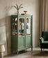Vitrina verde acristalada con libros y baldas de cristal en salón con cuadros — Antique Arte y Decoración