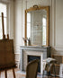Espejo antiguo dorado con corona sobre chimenea de mármol gris en estudio parisino — Antique Arte y Decoración
