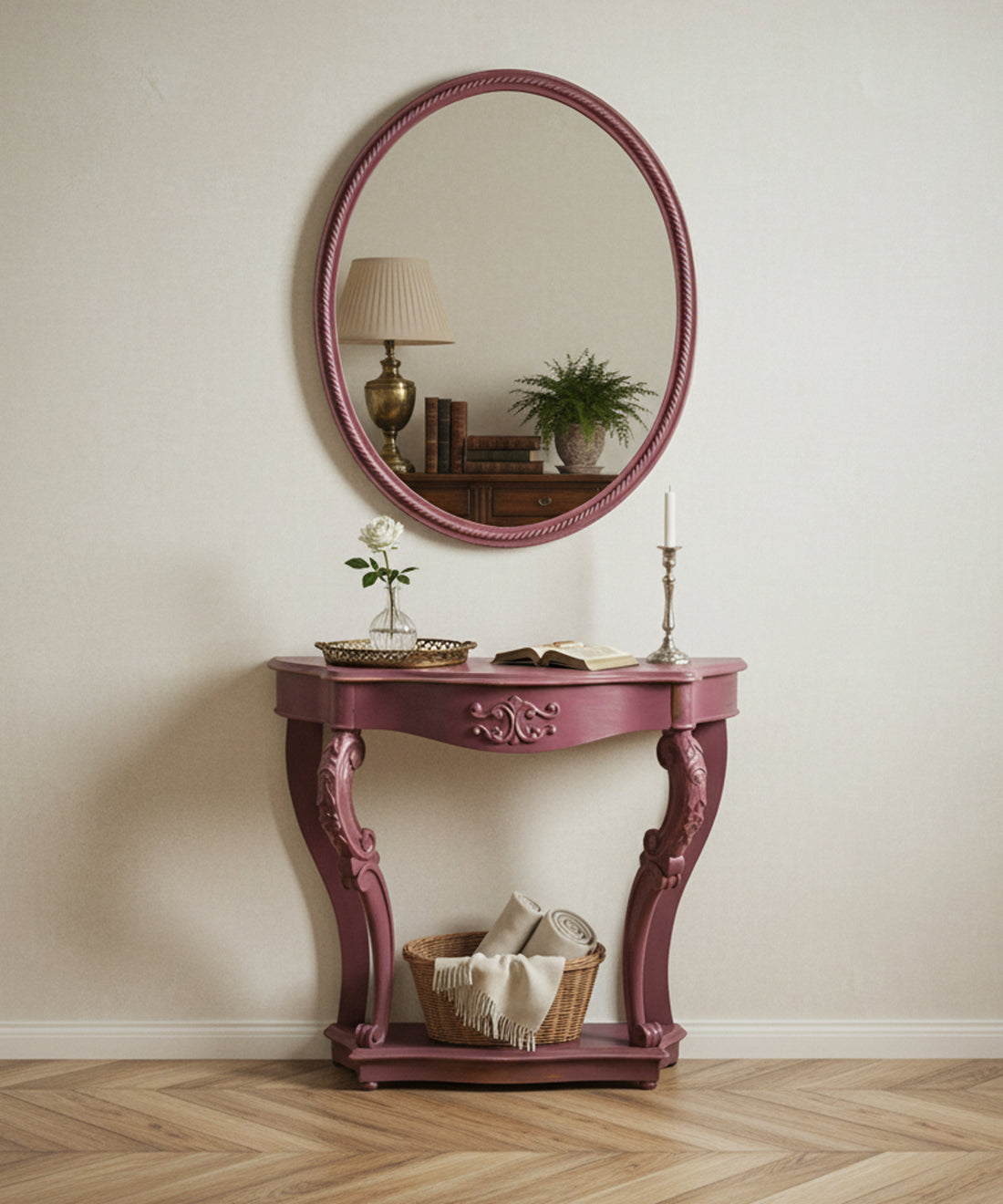 Consola rosa decorada en ambiente de salón clásico con espejo redondo y lámpara de mesa