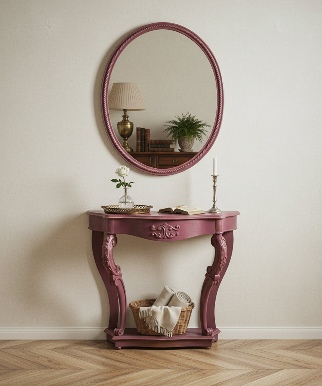 Consola rosa decorada en ambiente de salón clásico con espejo redondo y lámpara de mesa