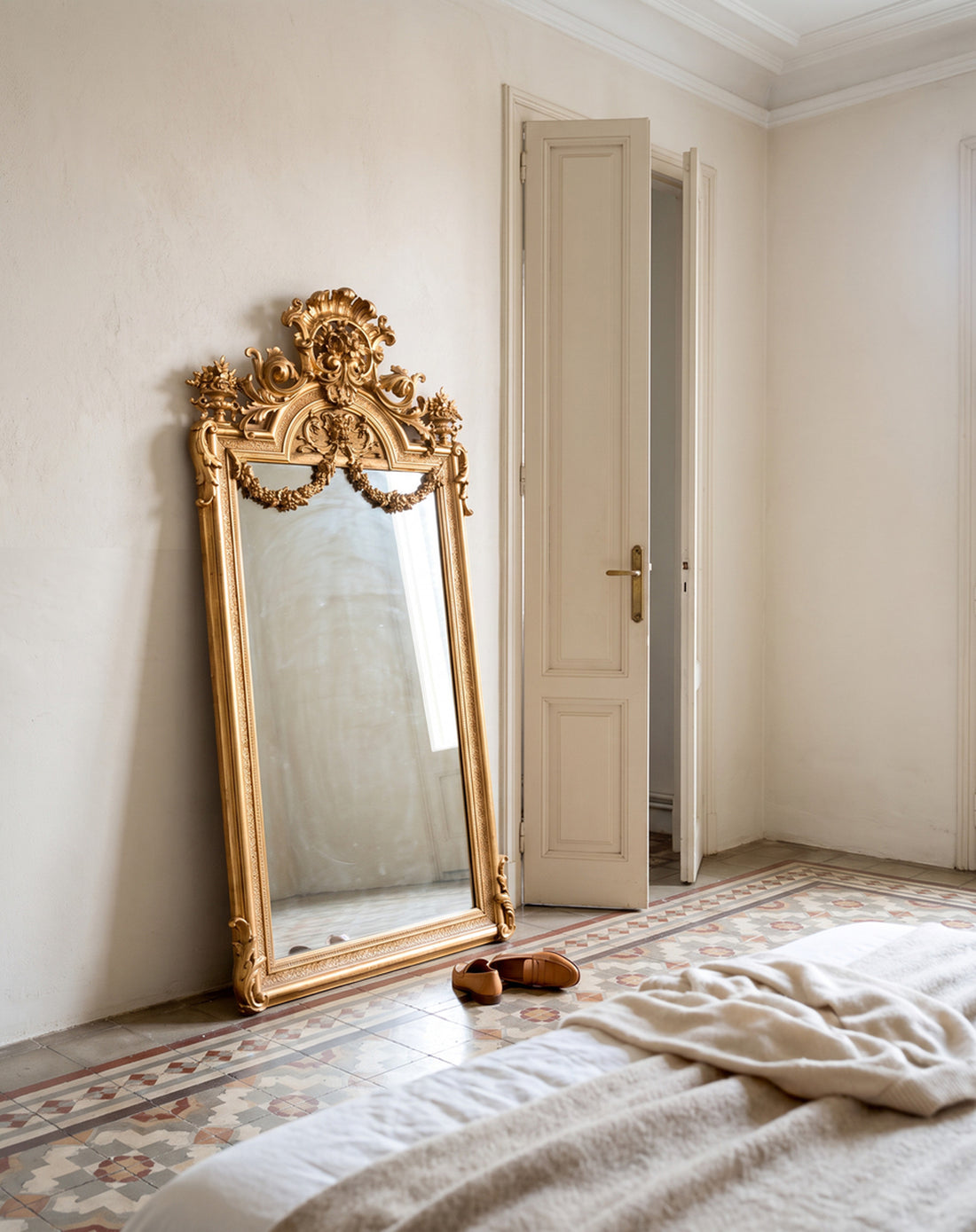 Espejo antiguo dorado Napoleón III apoyado en dormitorio con suelo hidráulico — Antique Arte y Decoración