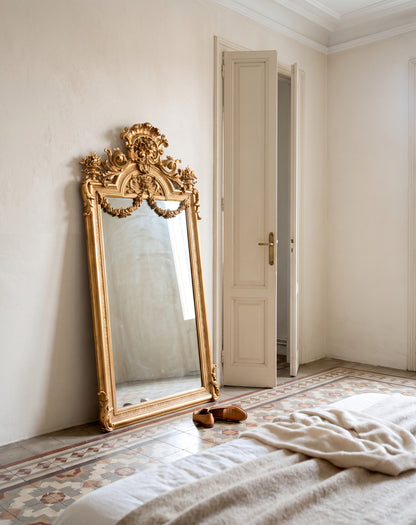 Espejo antiguo dorado Napoleón III apoyado en dormitorio con suelo hidráulico — Antique Arte y Decoración