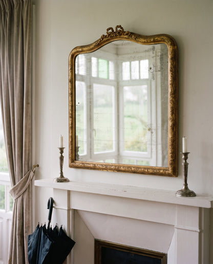 Espejo francés al pan de oro colgado sobre chimenea blanca en salón — Antique Arte y Decoración