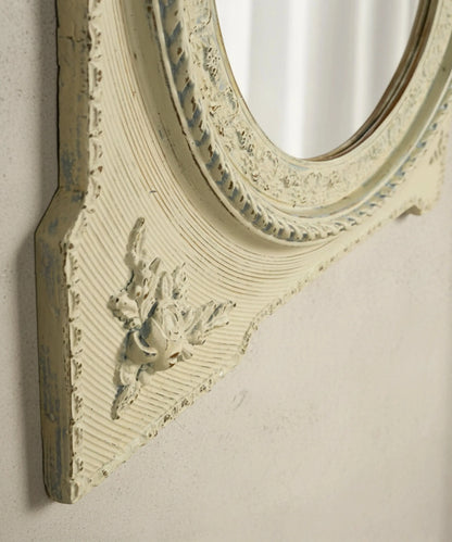 Detalle de aplique de rosas en relieve y pintura decapada en marco de espejo vintage.