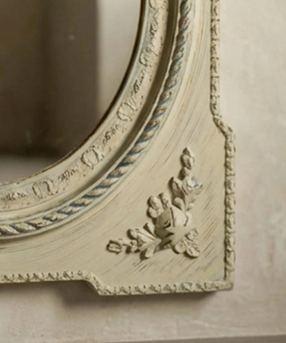 Detalle de aplique de rosas en relieve y pintura decapada en marco de espejo vintage.