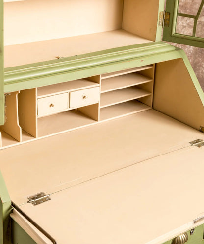 Primer plano de los cajoncitos interiores beige de un escritorio abatible antiguo restaurado.