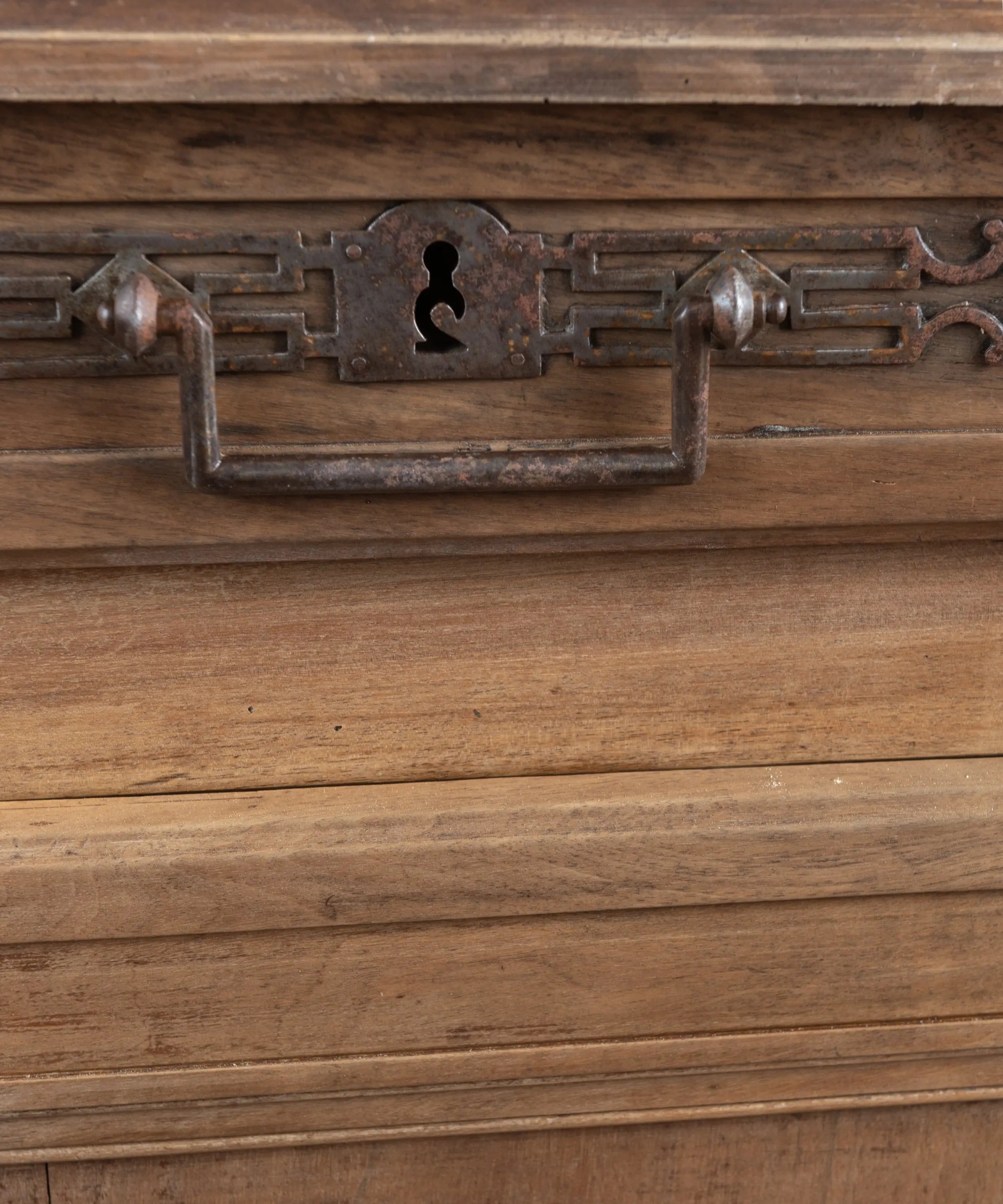 Detalle de imponentes placas y asas de hierro forjado a mano en cajón de mueble francés del siglo XIX.