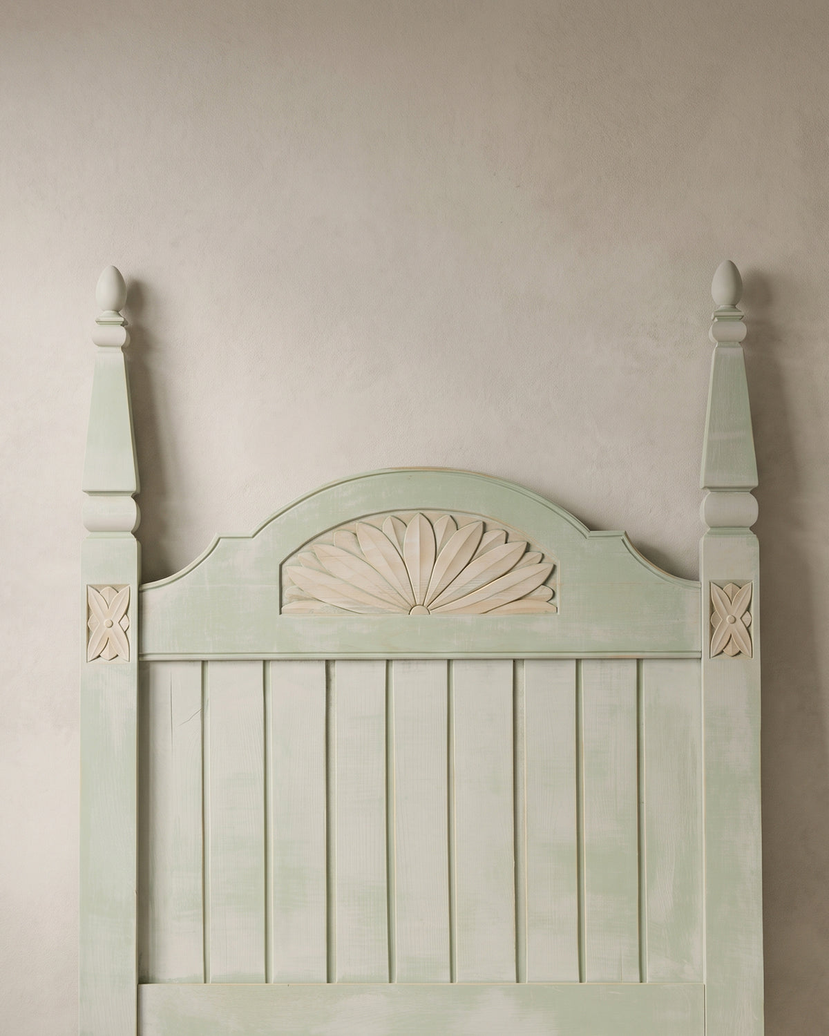 Detalle abanico tallado y rosetas en madera natural sobre cabecero verde — Antique Arte y Decoración