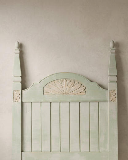 Detalle abanico tallado y rosetas en madera natural sobre cabecero verde — Antique Arte y Decoración