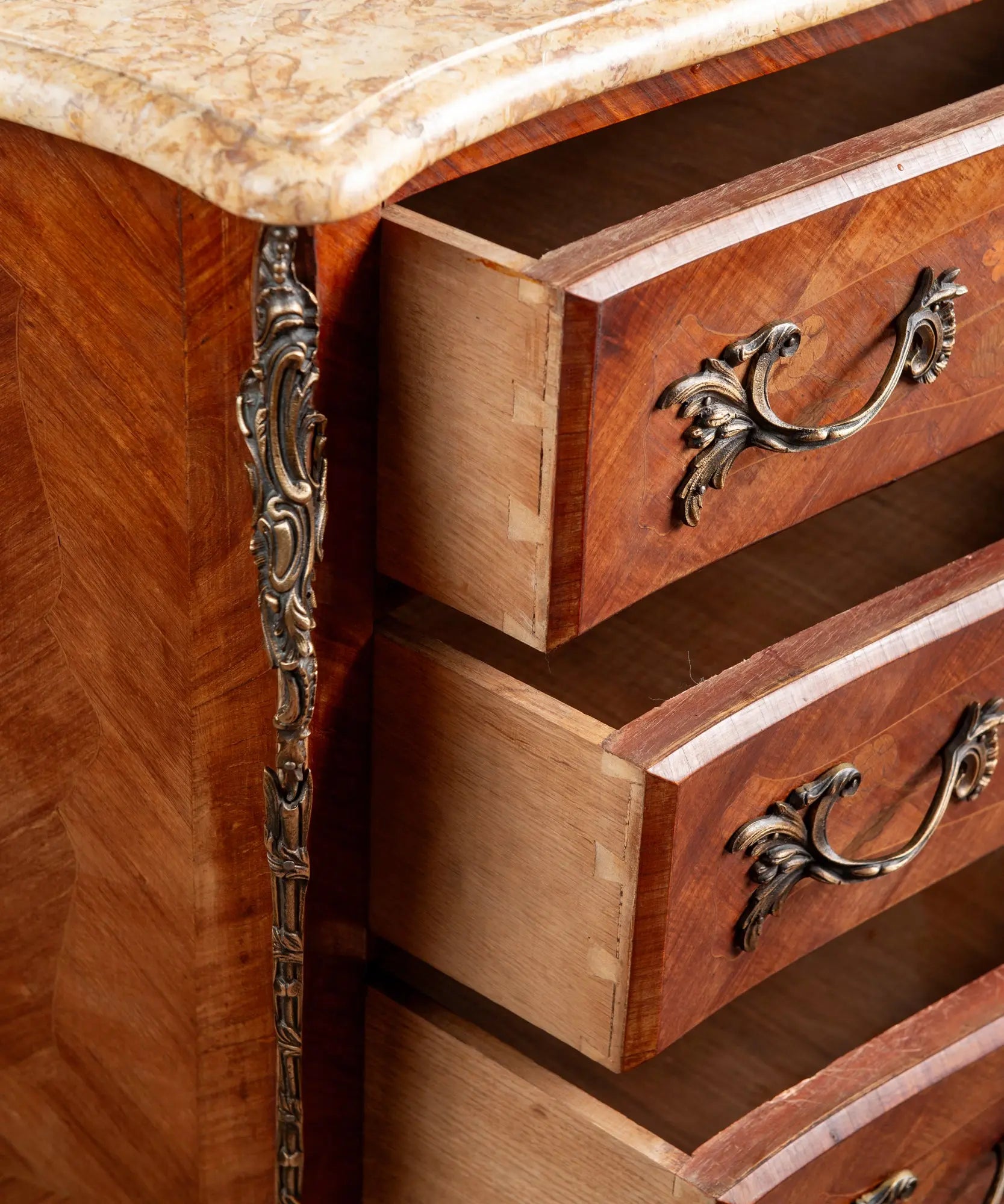 Cajones de cómoda vintage abiertos mostrando los ensambles de cola de milano en madera maciza.