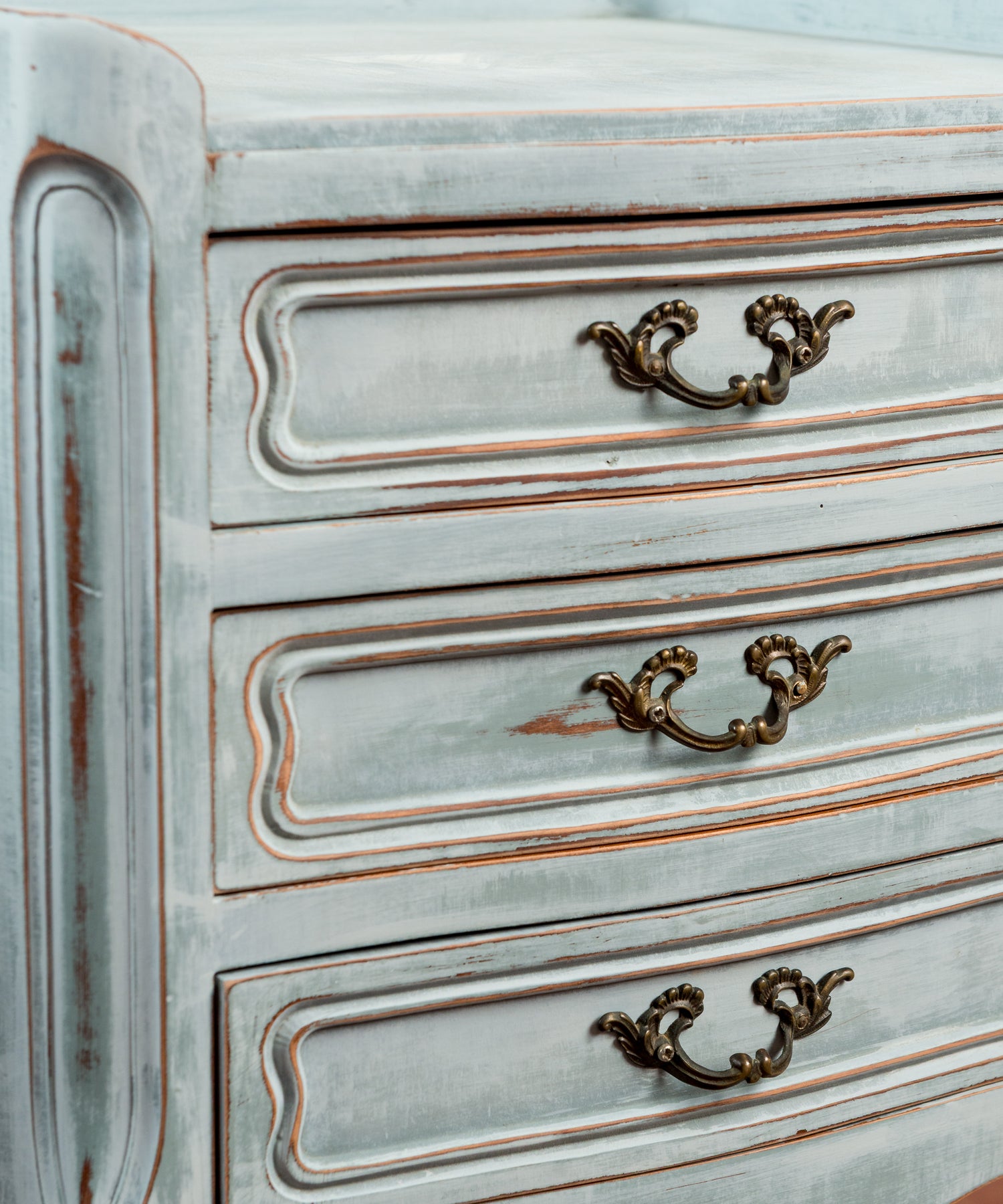Detalle tiradores de latón en volutas sobre frentes decapados en azul — Antique Arte y Decoración