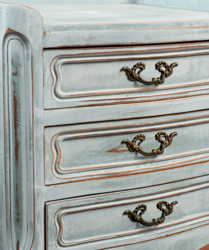 Detalle tiradores de latón en volutas sobre frentes decapados en azul — Antique Arte y Decoración