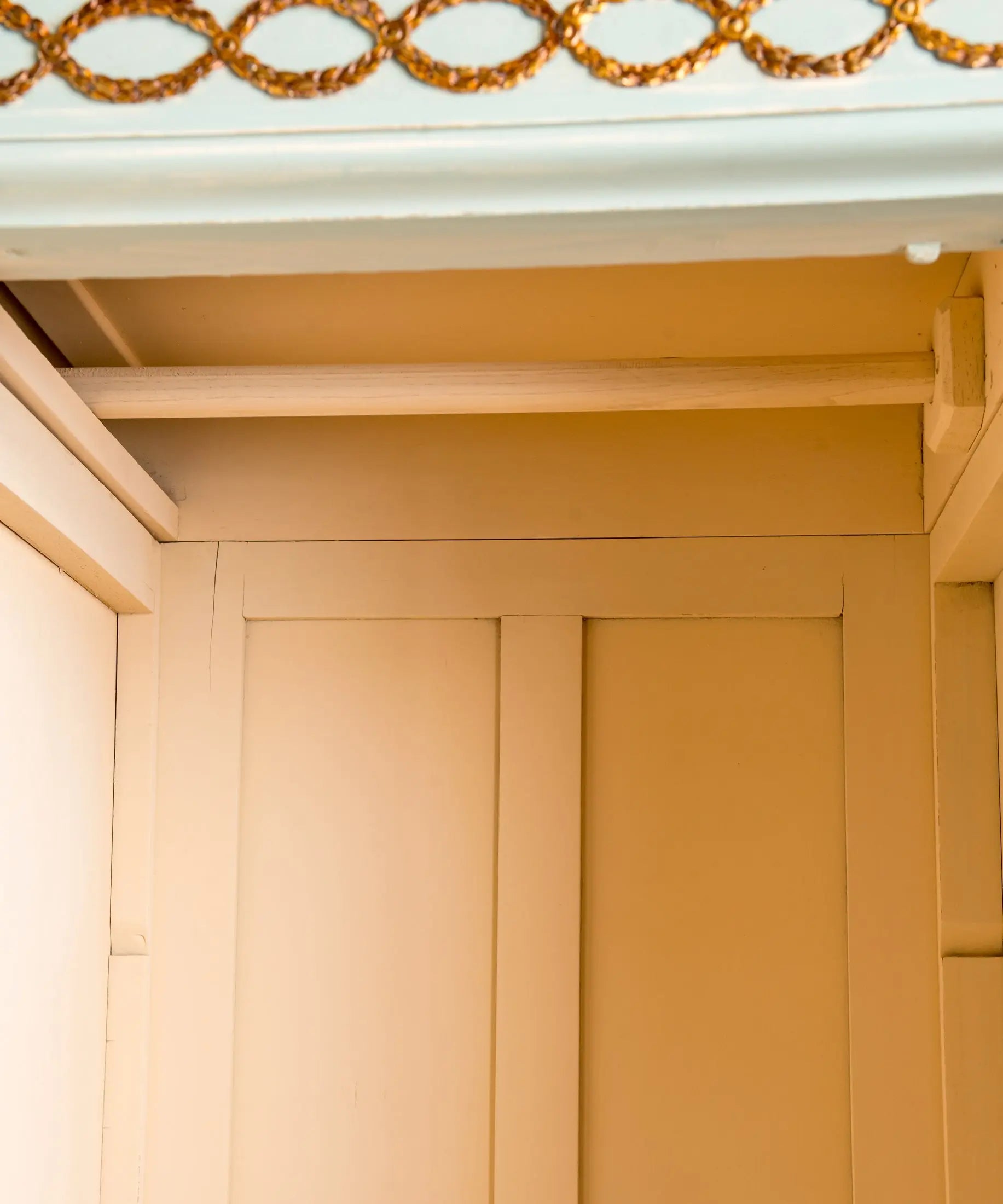 Detalle interior en ocre con barra de colgar de madera del armario — Antique Arte y Decoración