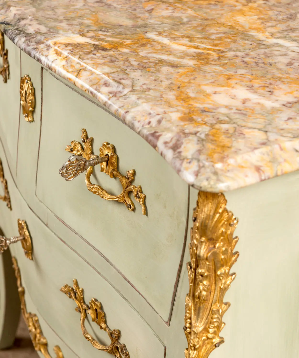 detalle Cómoda vintage de madera estilo francés Luis XV pintada en verde claro con bronces y mármol.