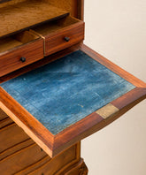 Plano detalle del abatible del secretaire con tapicería de terciopelo azul original y tiradores de bronce.