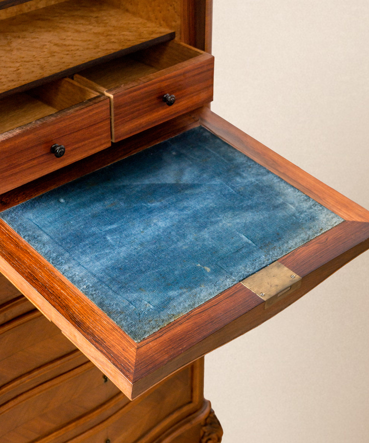 Plano detalle del abatible del secretaire con tapicería de terciopelo azul original y tiradores de bronce.