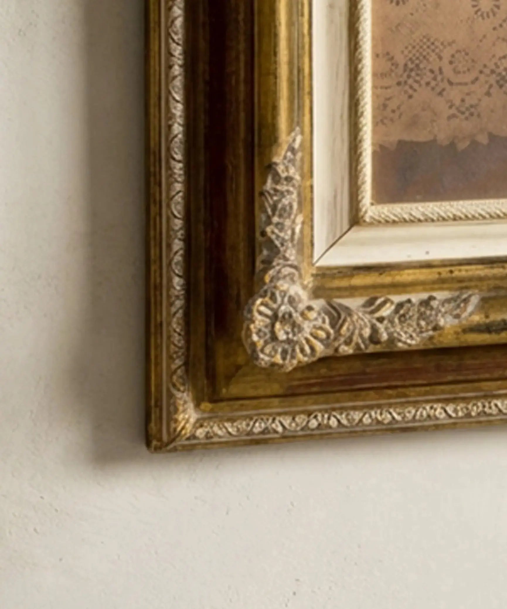 Primer plano de moldura tallada con flores y rocalla en oro viejo de marco de cuadro vintage.