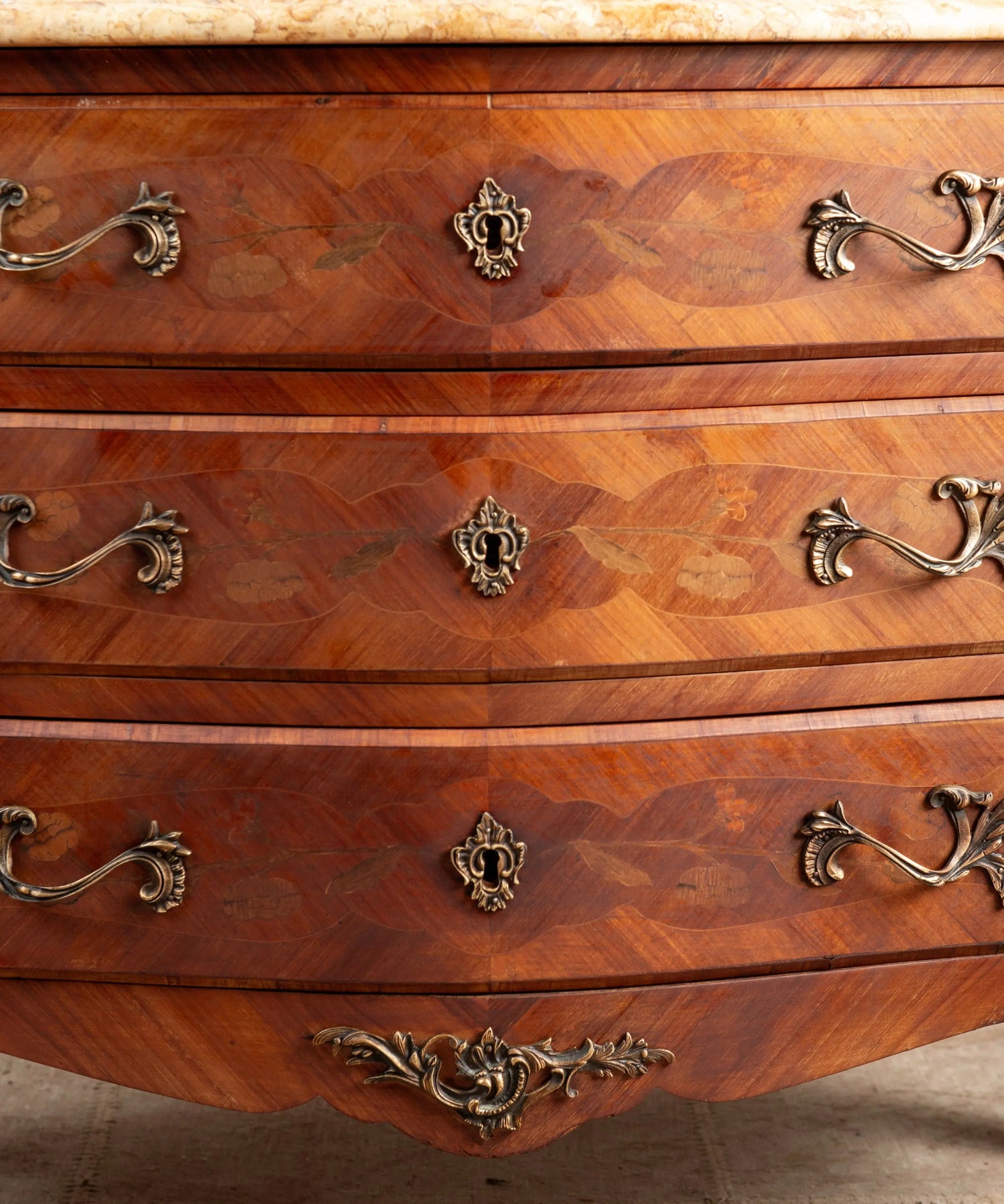 Cómoda bombé de estilo Luis XV con marquetería floral y tapa de mármol