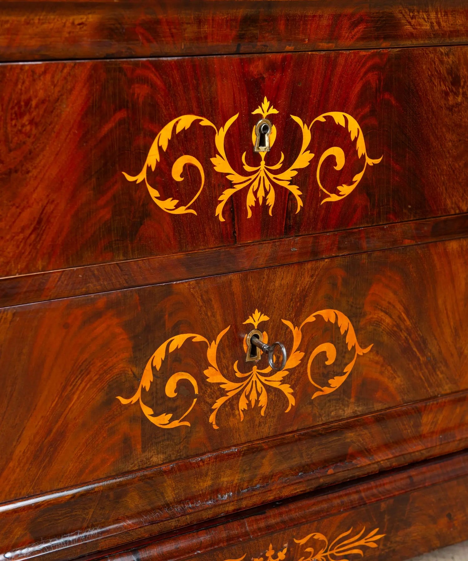 Primer plano del veteado de caoba de pluma y marquetería de boj con motivos florales.