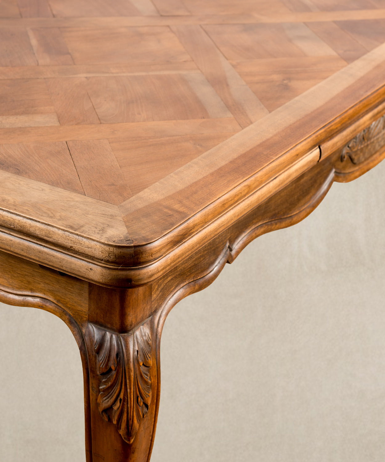 detalle Perspectiva lateral de mesa de comedor vintage resaltando la curvatura de las patas y el acabado de la madera.