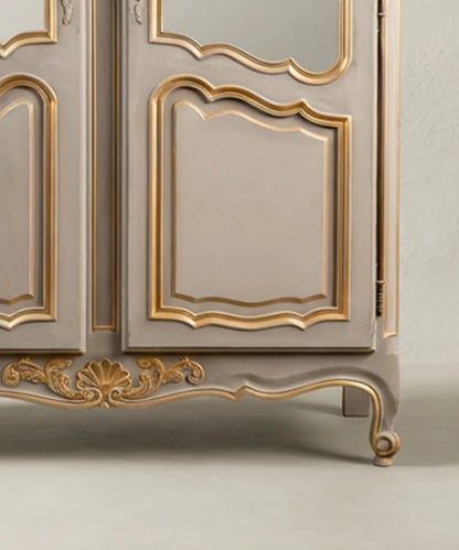 Detalle de faldón con talla de concha dorada y pata cabriolé en vitrina antigua restaurada.