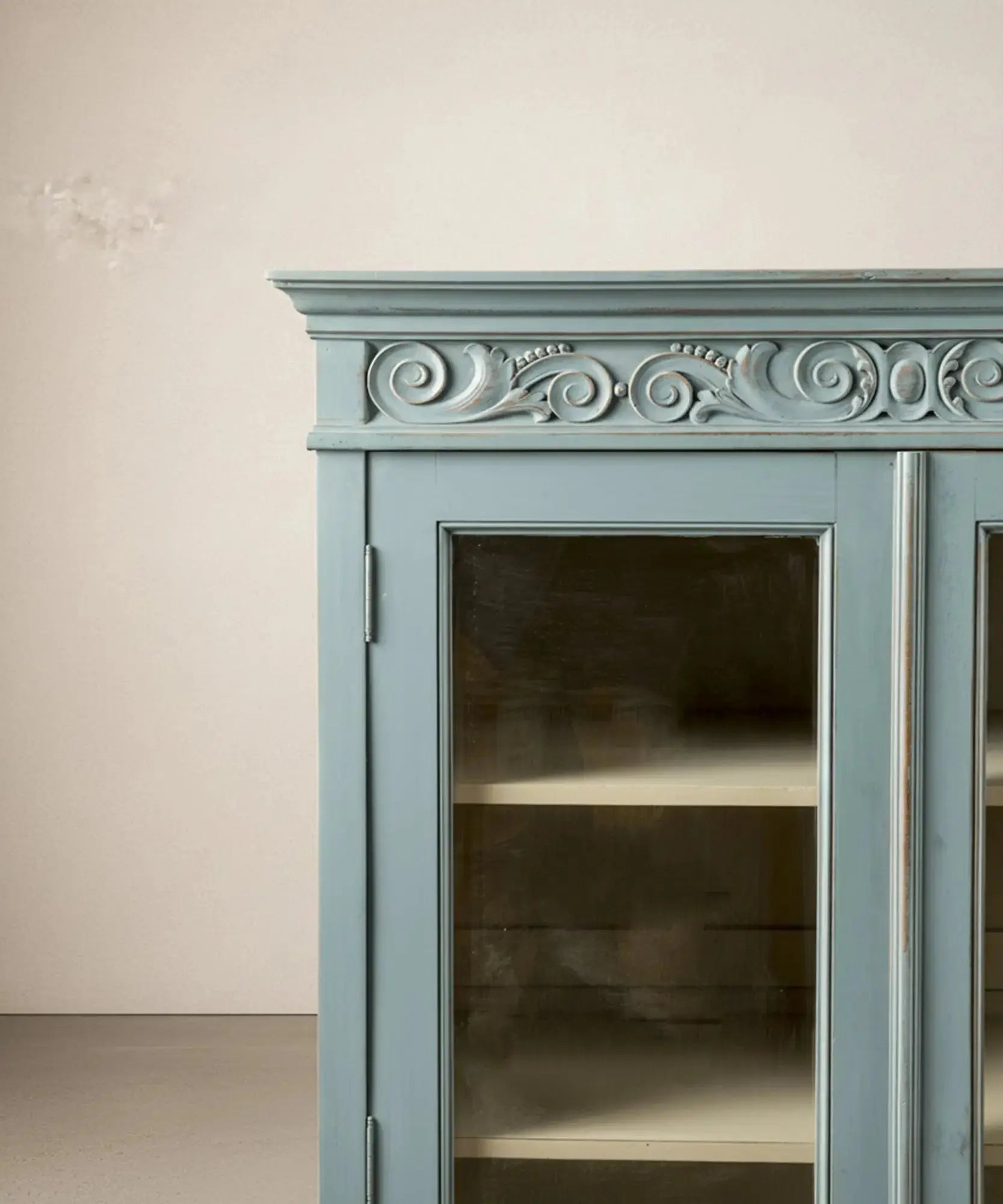 Primer plano del friso superior tallado con motivos de volutas neoclásicas.