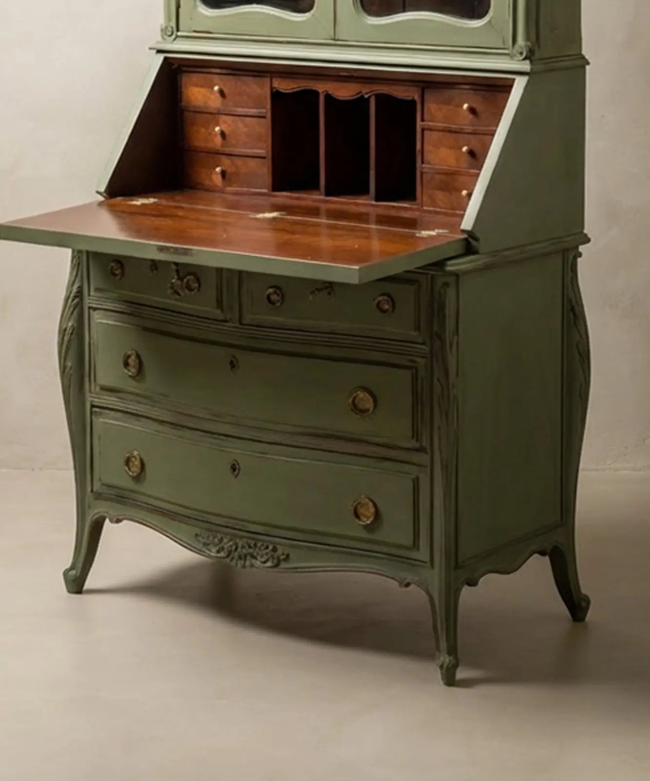 Bureau verde salvia decorando un salón clásico contemporáneo con libros antiguos y decoración sofisticada.