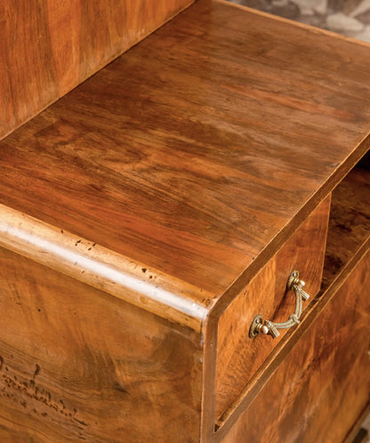 Primer plano de la veta de madera de raíz de nogal y tirador clásico en cajón vintage.