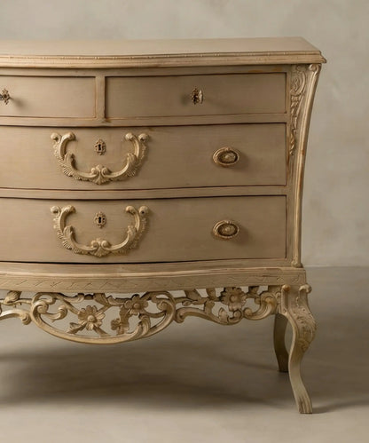 Detalle lateral de patas cabriolé y desgaste artesanal en aristas de cómoda abombada clásica.