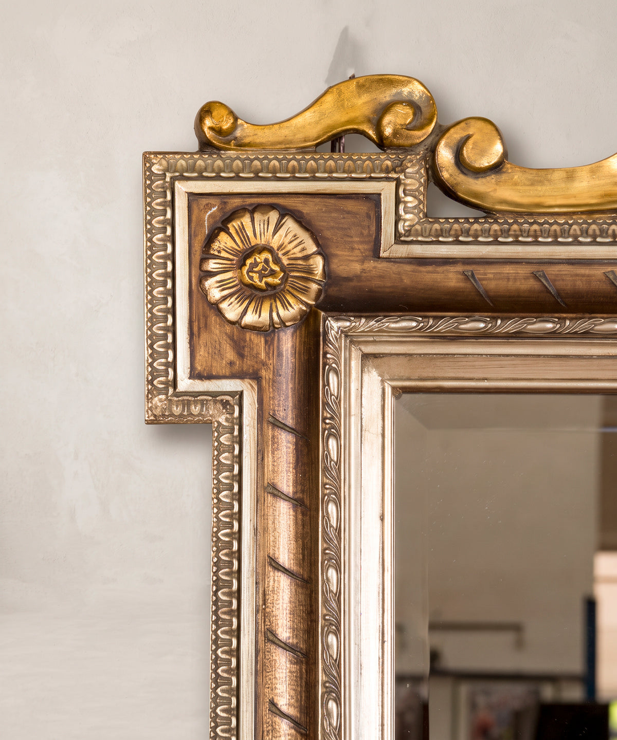 Detalle esquina superior del espejo con roseta dorada y marco de orejetas — Antique Arte y Decoración