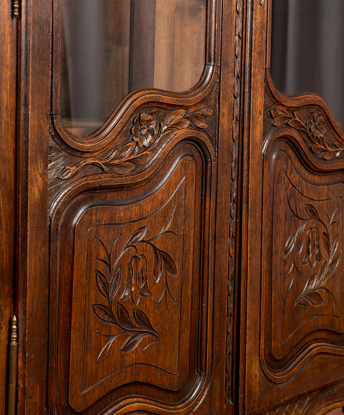 Detalle panel bajo con campanillas y laurel tallados en puerta de vitrina de roble — Antique Arte y Decoración