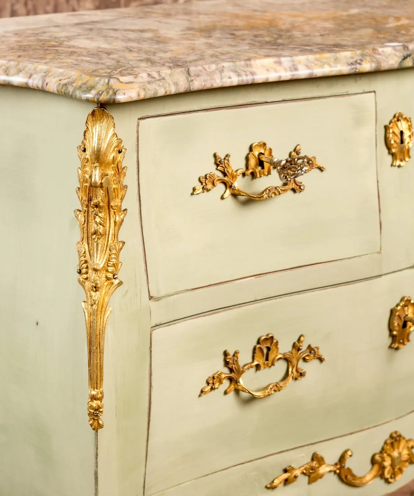 detalle Cómoda vintage de madera estilo francés Luis XV pintada en verde claro con bronces y mármol.