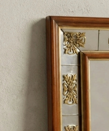 Detalle de rosetones de bronce dorado y cristal antiguo en marco de espejo neoclásico.