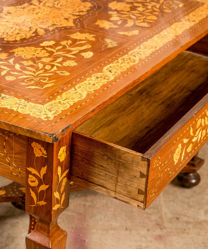 Cajón oculto abierto mostrando ensambles manuales de cola de milano en mesa marqueteada antigua.