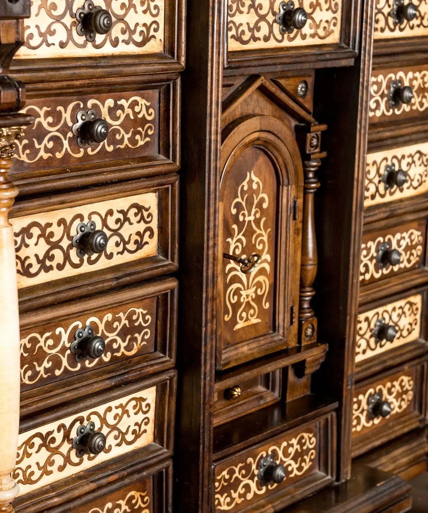 detalle cajones Bargueño papelera español vintage de madera de nogal sobre mesa de pie de puente torneado.