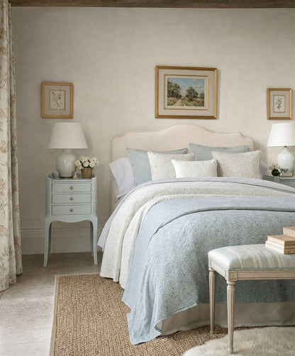 Mesitas de noche azul celeste junto a cabecero tapizado en dormitorio — Antique Arte y Decoración