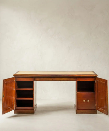 Detalle del interior de los pedestales del escritorio, mostrando estantes de madera y cajón con tirador de latón.