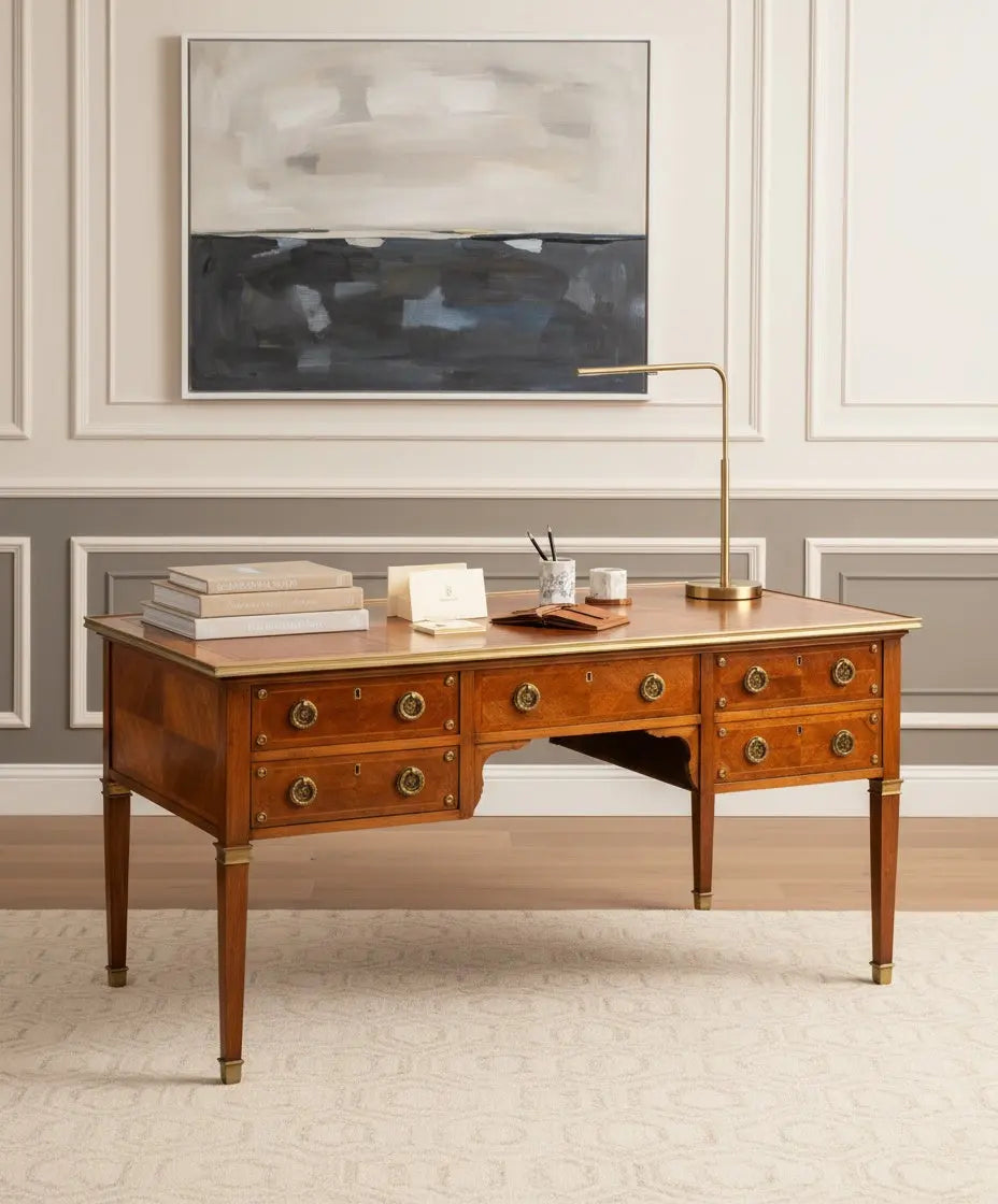 Gran escritorio de centro estilo Luis XVI de madera con cinco cajones y herrajes de bronce en piso clasico