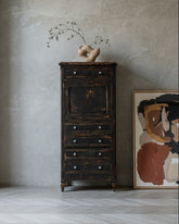 Escritorio secreter antiguo negro decapado junto a cuadro abstracto en salón minimalista con suelo de espiga.