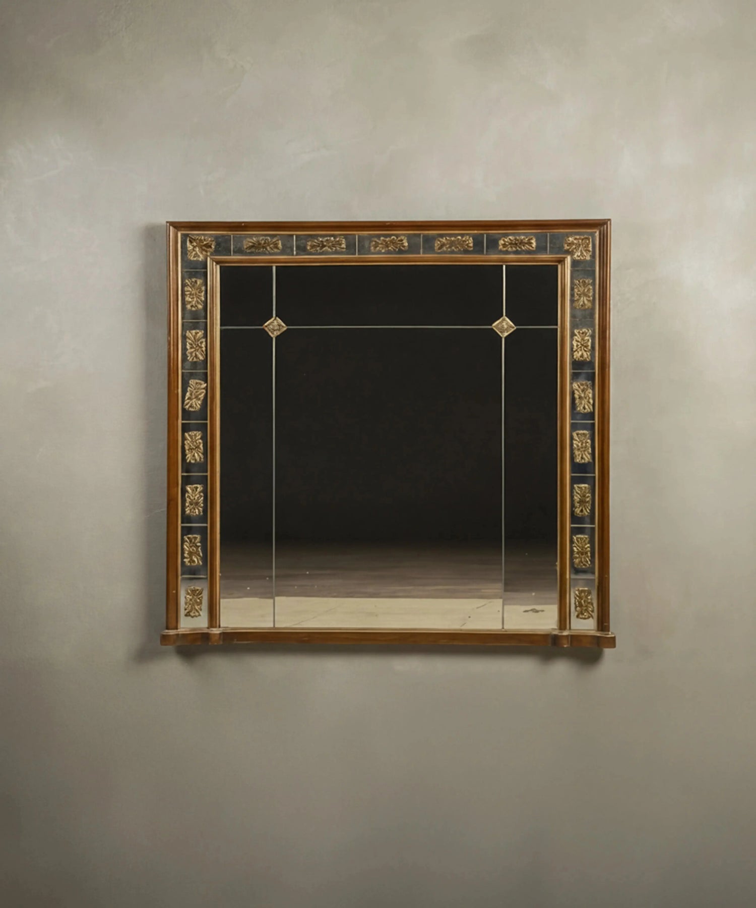 Espejo de pared vintage estilo Imperio con marco de cristal segmentado y apliques dorados.
