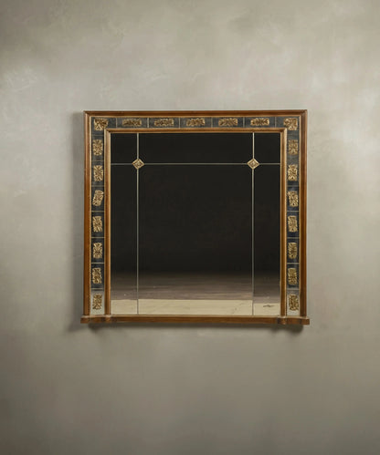 Espejo de pared vintage estilo Imperio con marco de cristal segmentado y apliques dorados.