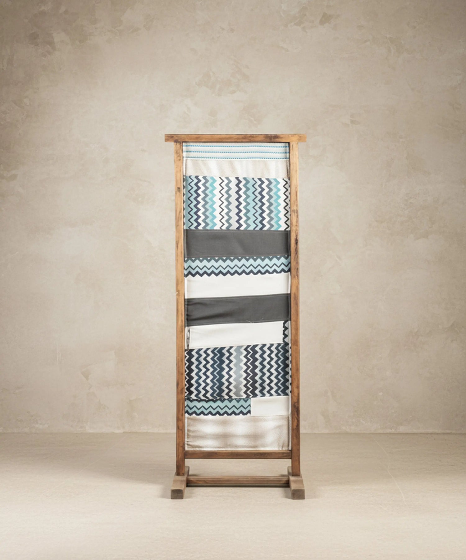 Parte trasera de espejo de suelo tapizada con tela geométrica de zigzag azul y gris.