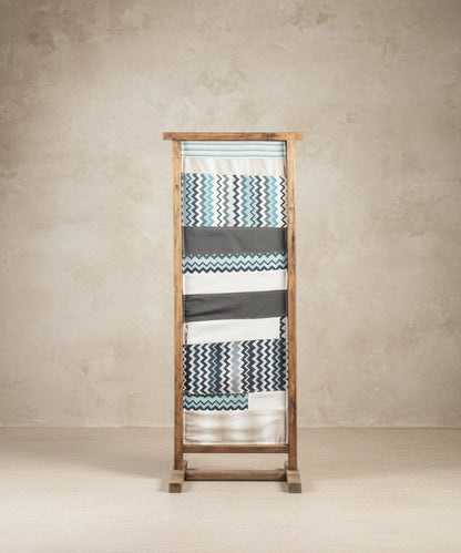 Parte trasera de espejo de suelo tapizada con tela geométrica de zigzag azul y gris.