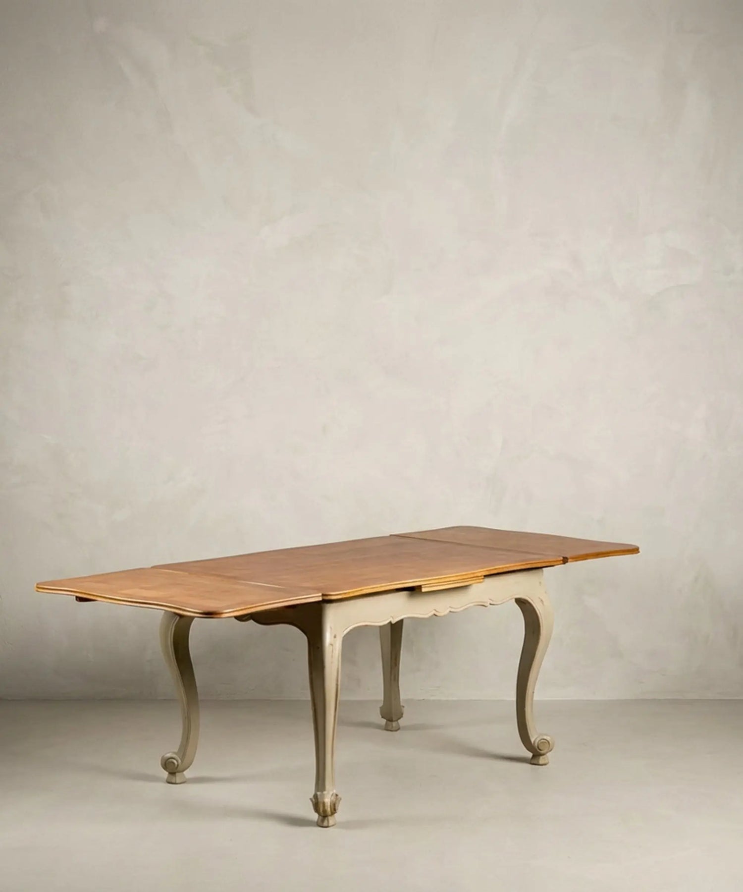 Mesa de comedor extensible antigua totalmente abierta mostrando alas laterales y tablero de madera.