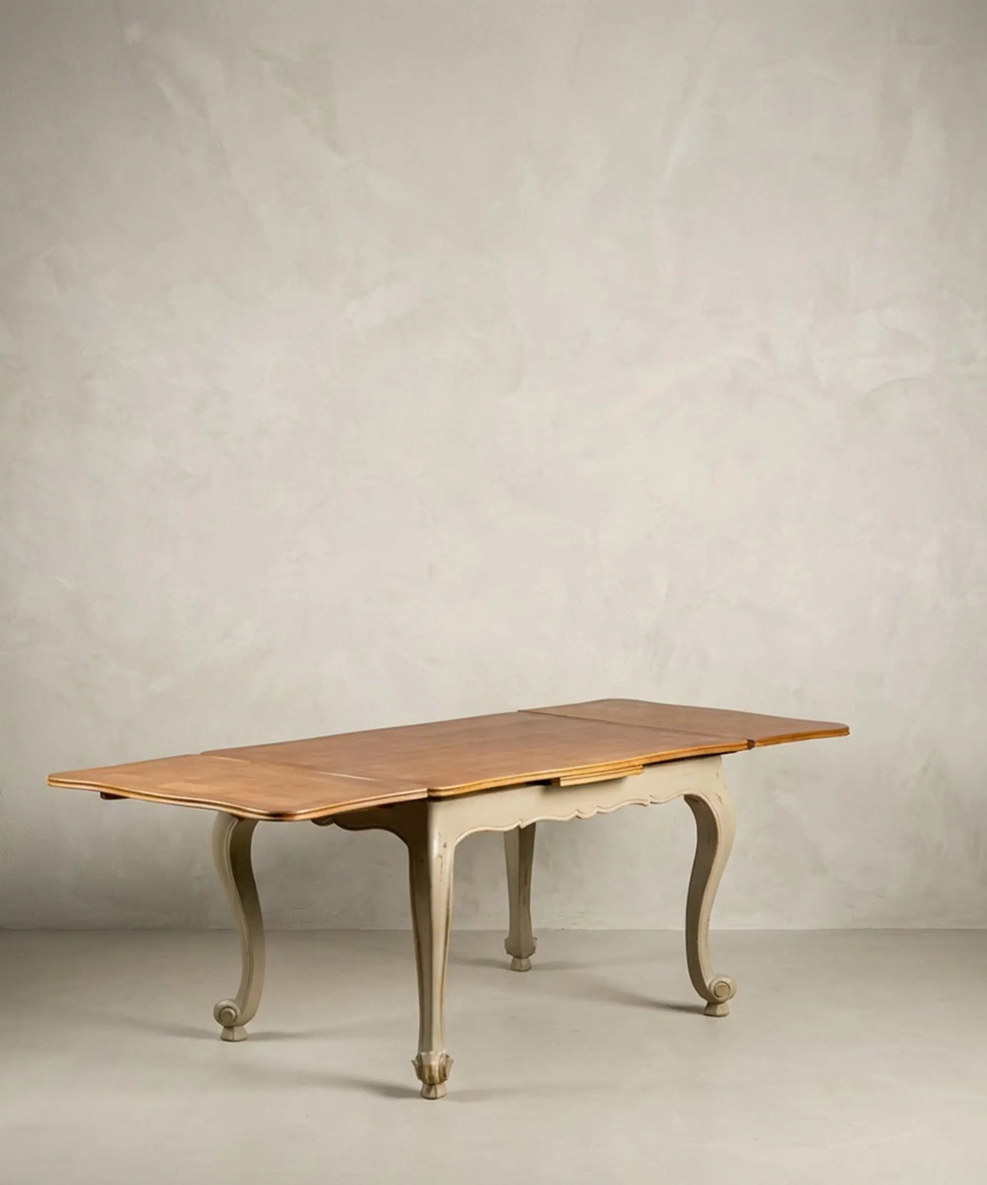 Mesa de comedor extensible antigua totalmente abierta mostrando alas laterales y tablero de madera.