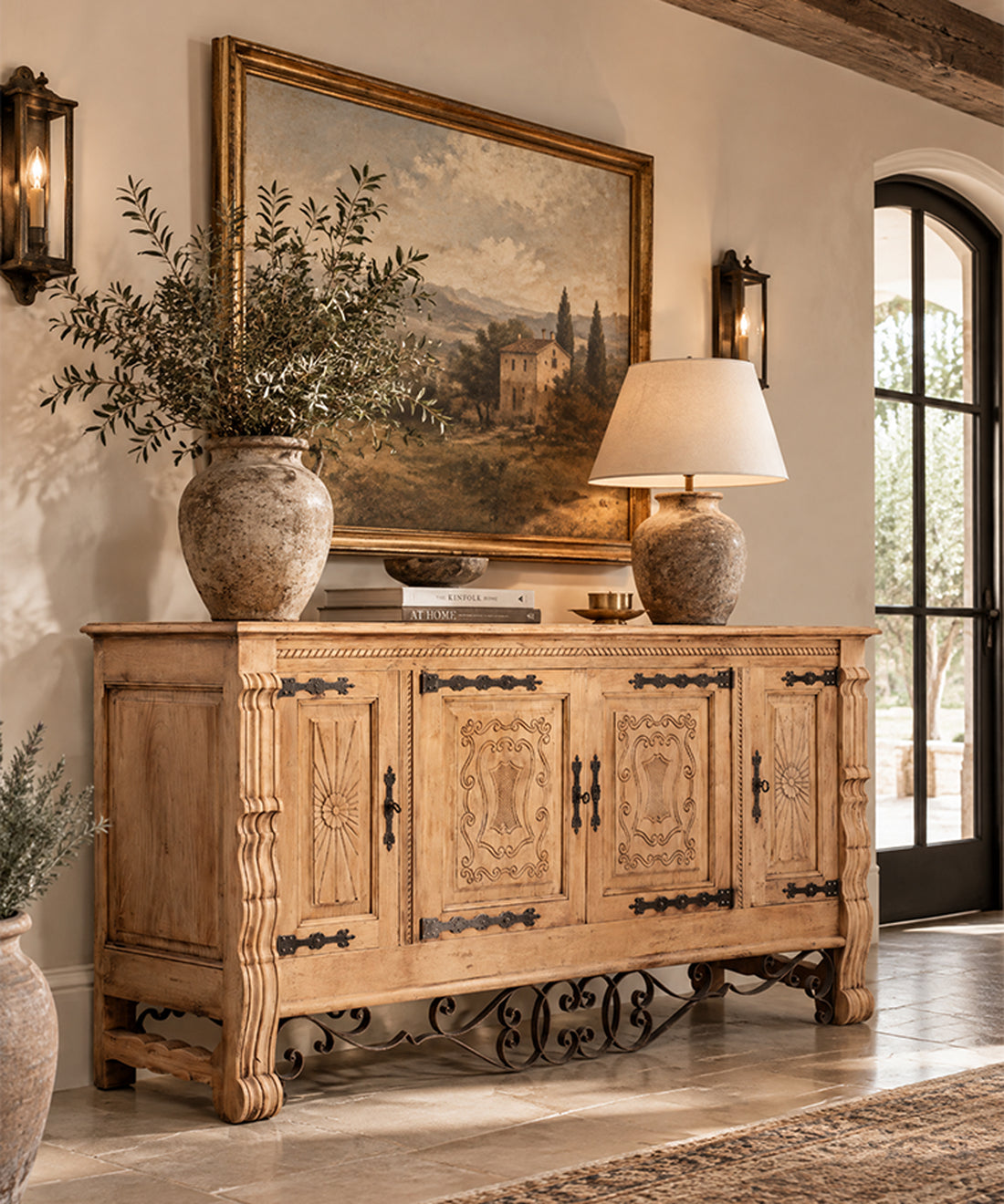 Aparador de roble tallado con forja en salón mediterráneo bajo cuadro de paisaje — Antique Arte y Decoración