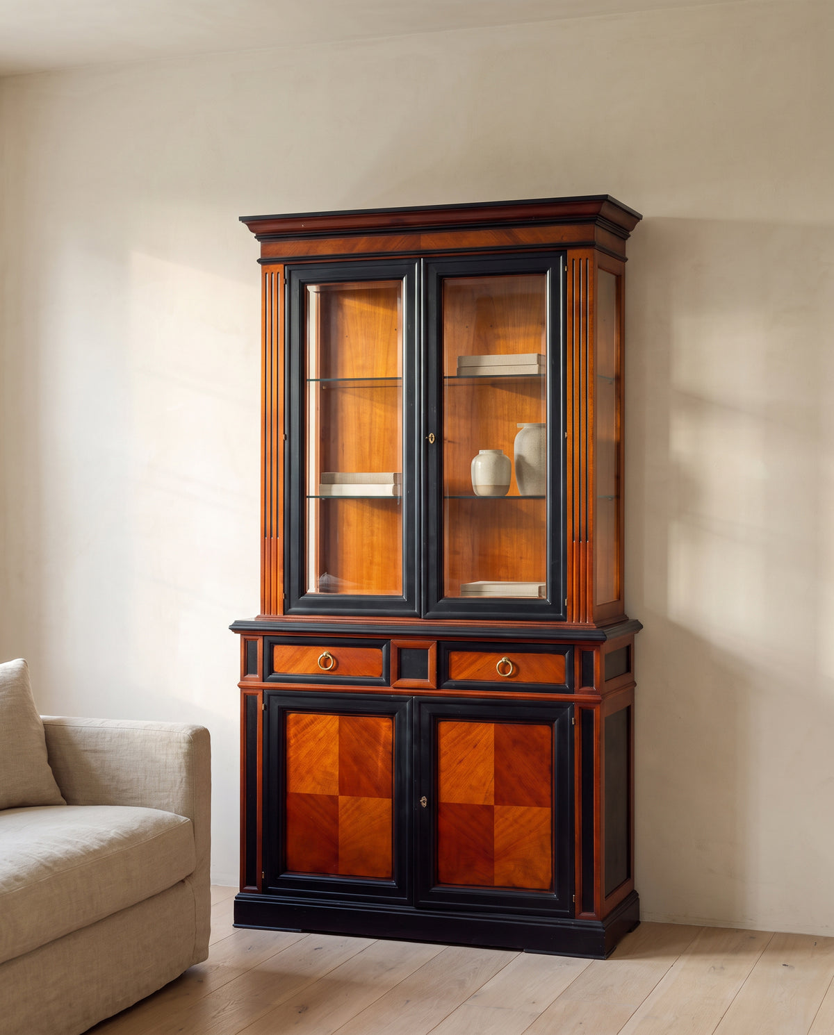 Vitrina de caoba y negro mate en salón junto a sofá de lino — Antique Arte y Decoración