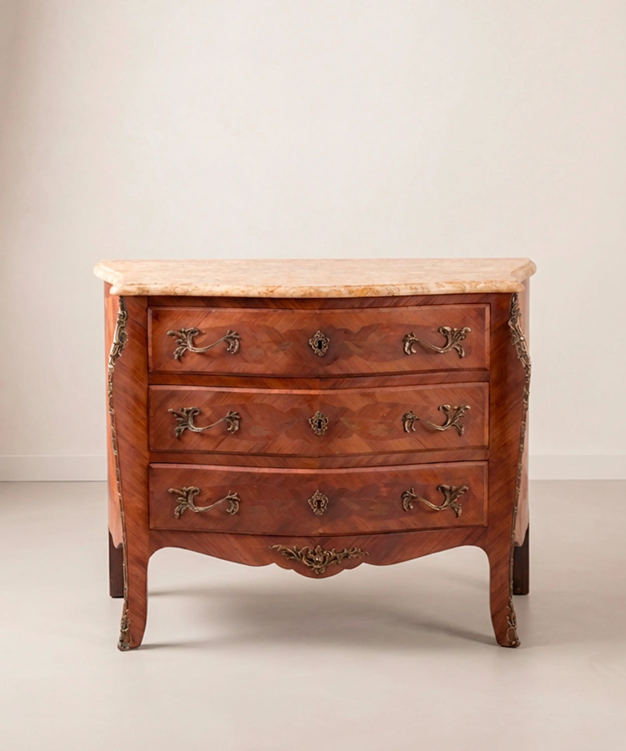 Cómoda panzuda estilo Luis XV de tres cajones con marquetería, bronces y tapa de mármol.