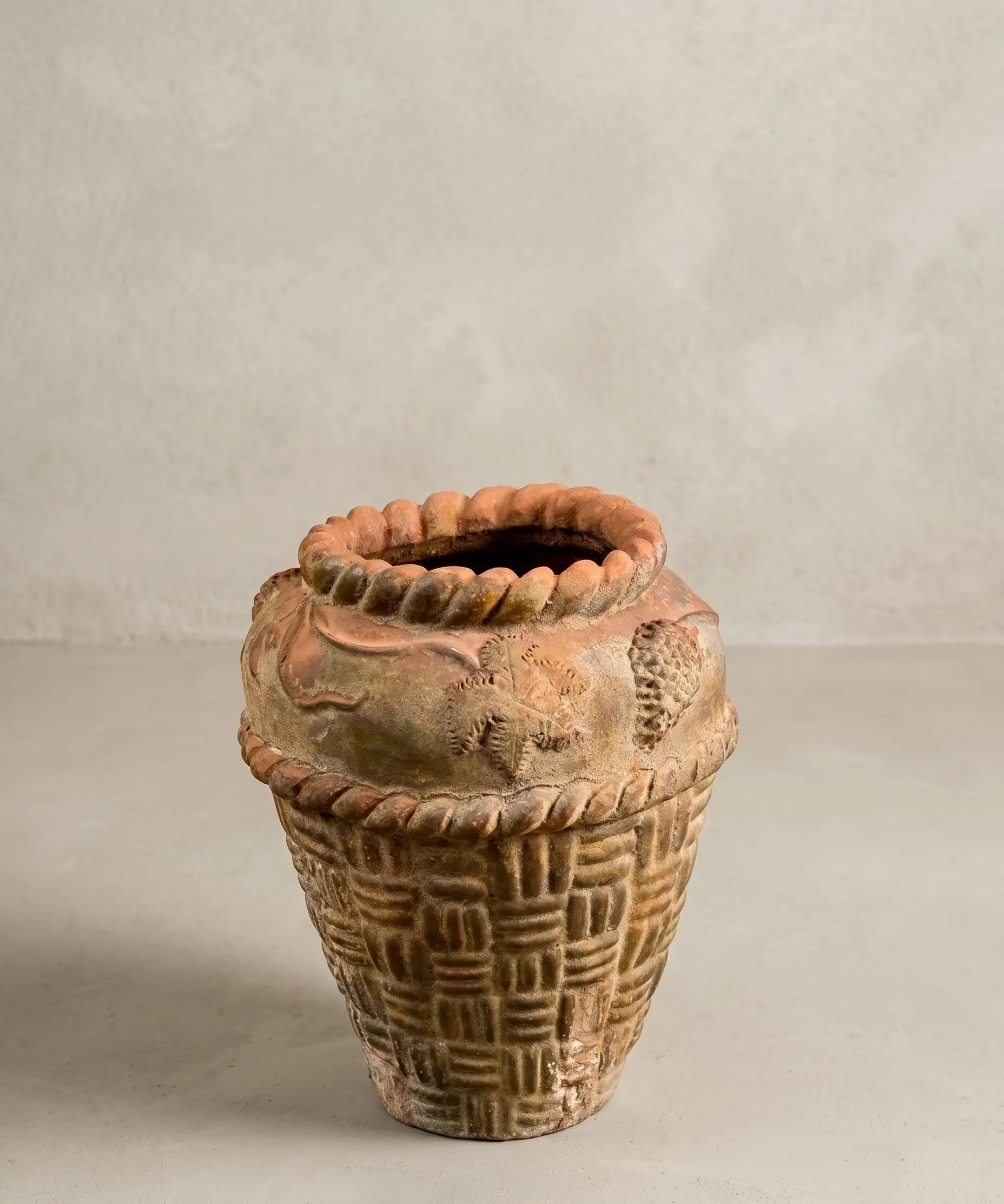 Macetero antiguo de terracota con relieve de cestería y motivos florales